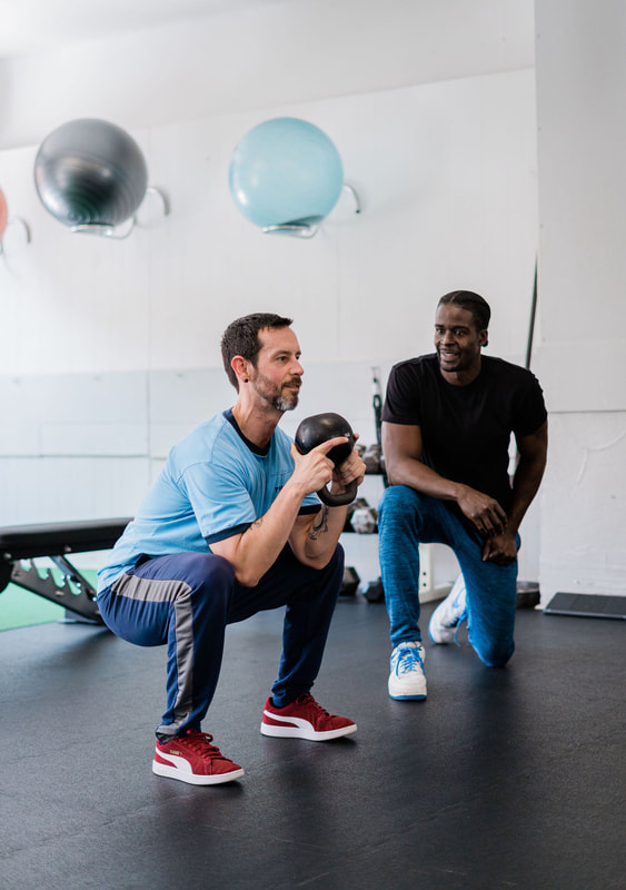 Man executing kettlebell squat, showcasing Evanston's premium fitness offerings.