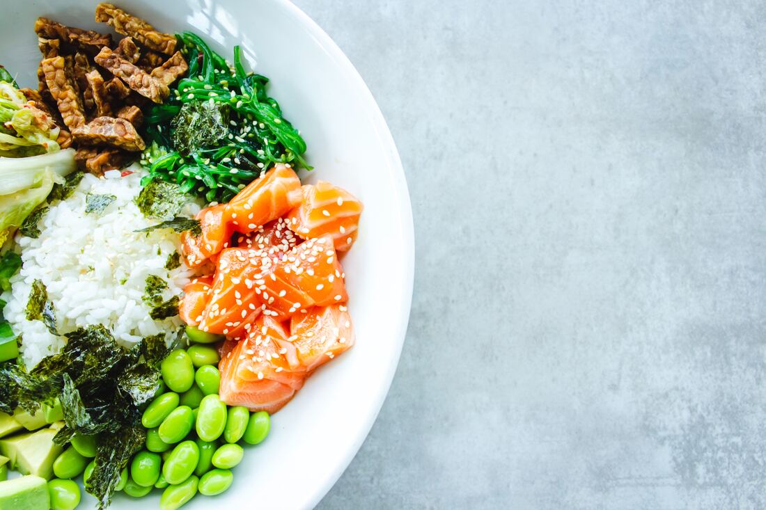 Nutrition guidelines bowl with salmon and vegetables for active individuals.